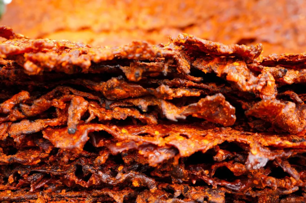 kilishi being prepared with peanut spice coating