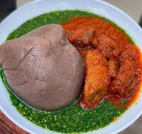 Bowl of green ewedu soup with amala